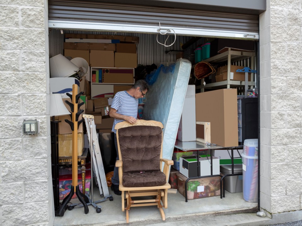 man holding a lock in front of a storage warehouse holding the contents of his home 