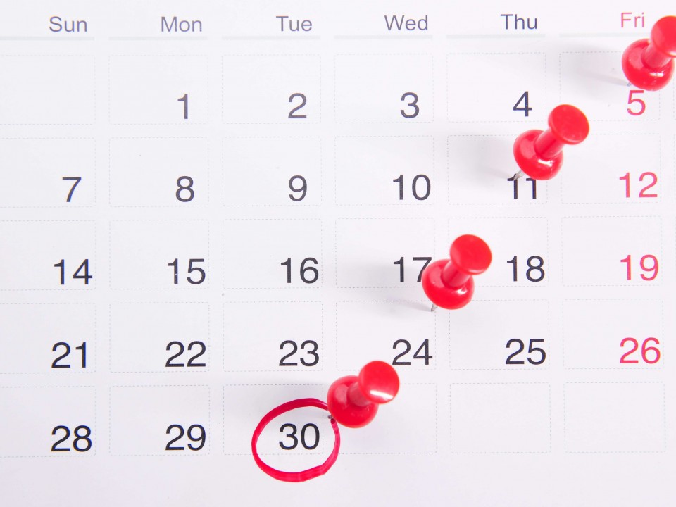 calendar with red pins and date circled in red 